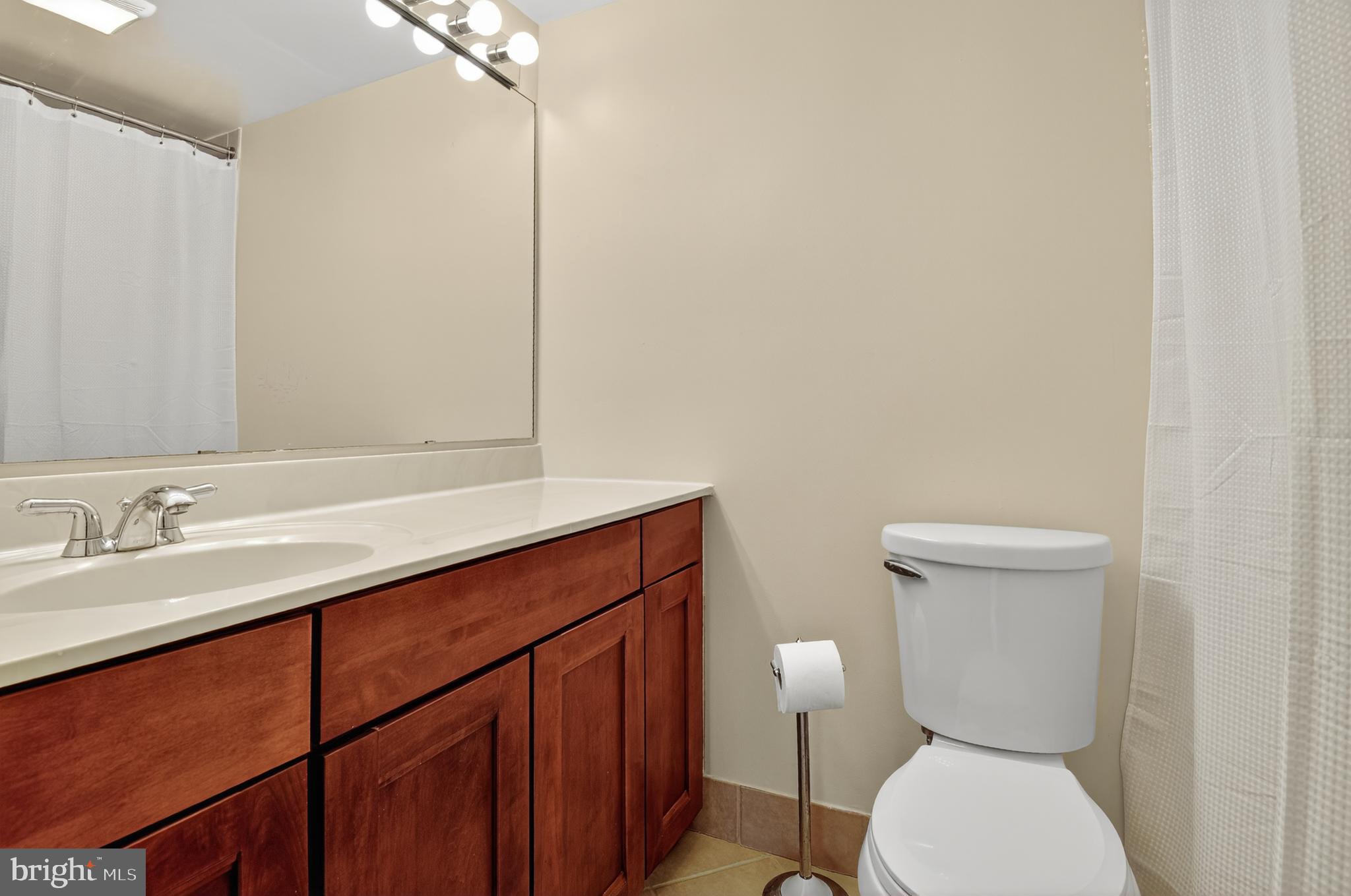 1493 A Street Northeast Washington, DC 20002 - Photo 22 of 31 a bathroom with a toilet a sink and mirror