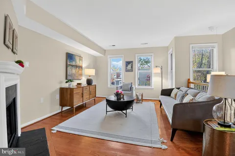 a living room with furniture fireplace and a large window