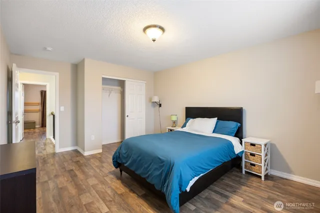 a bedroom with a bed and a wooden floor