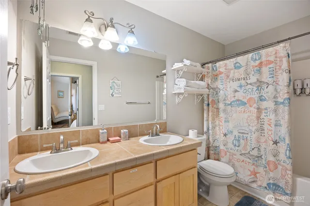 a bathroom with a double vanity sink mirror and toilet