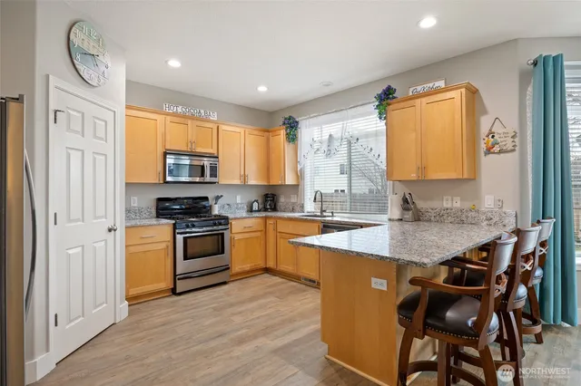 a kitchen with stainless steel appliances granite countertop a white cabinets and a stove top oven