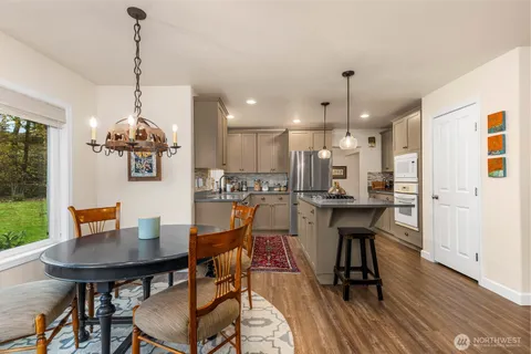 a dining room filled a chandelier a potted plant and a dining table with chairs