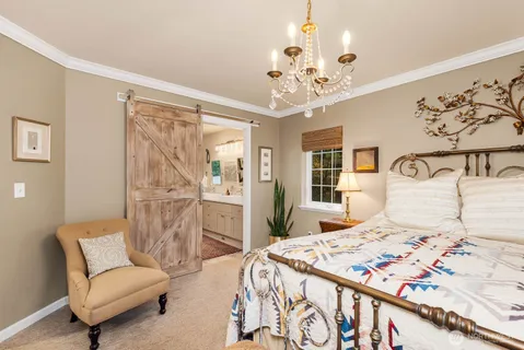 a bedroom with a large bed and a chandelier