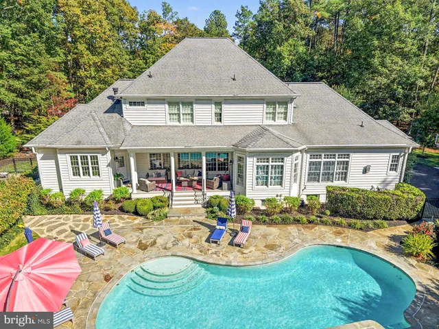 a view of a house with a swimming pool and a yard