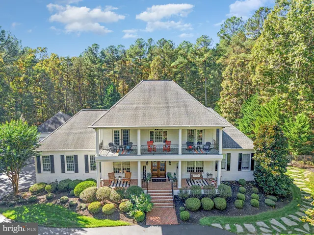 an aerial view of a house with a swimming pool a yard and a fountain