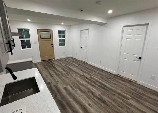 a view of a hallway with wooden floor and windows