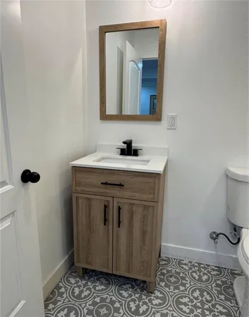 a bathroom with a sink a toilet and mirror