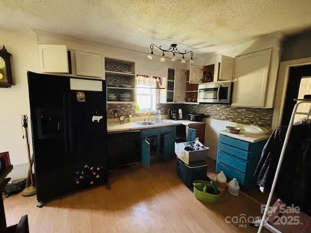 a kitchen with stainless steel appliances kitchen island granite countertop a refrigerator stove and sink