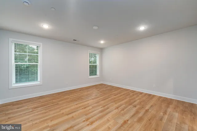 a view of empty room with wooden floor