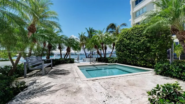 a view of backyard with swimming pool and seating space