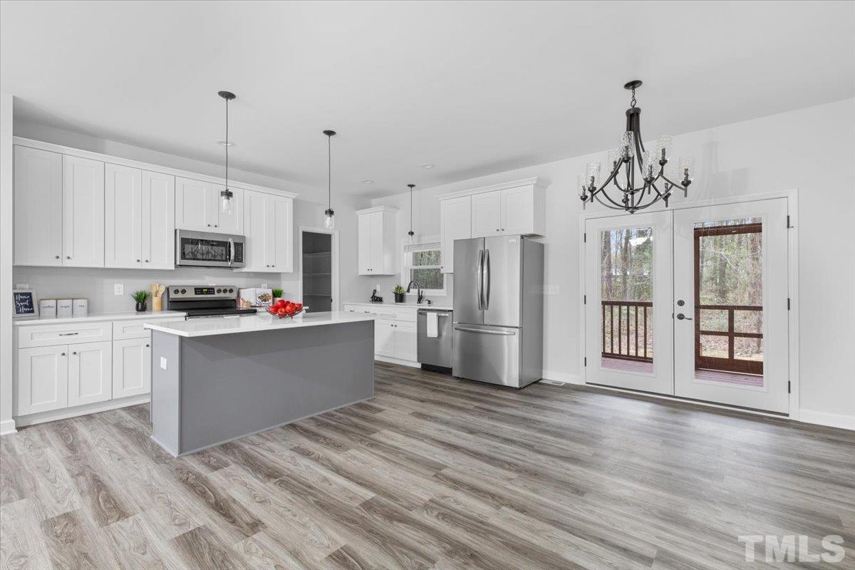 1893 Pilot-Riley Road Zebulon, NC 27597 - Photo 14 of 50 a kitchen with granite countertop a refrigerator oven a sink dishwasher and white cabinets with wooden floor