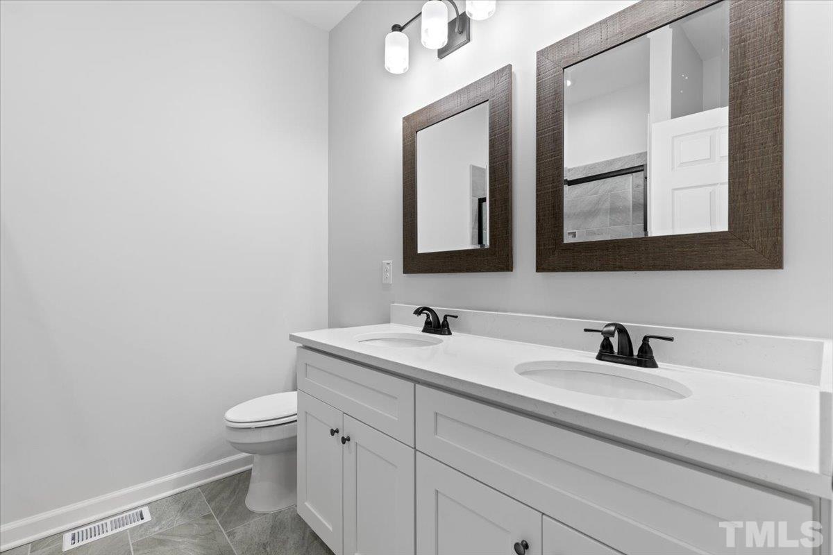 1893 Pilot-Riley Road Zebulon, NC 27597 - Photo 28 of 50 a bathroom with 2 sink and a mirror