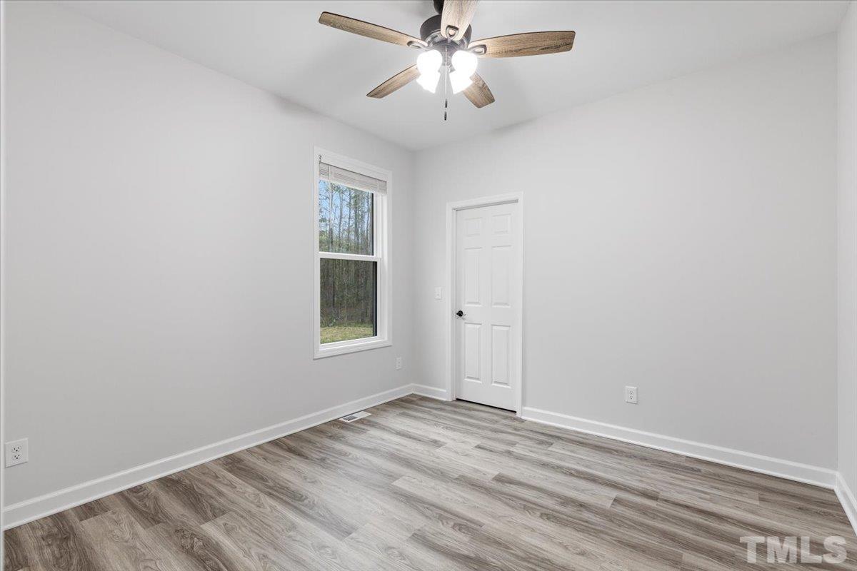 1893 Pilot-Riley Road Zebulon, NC 27597 - Photo 30 of 50 an empty room with a window and a ceiling fan
