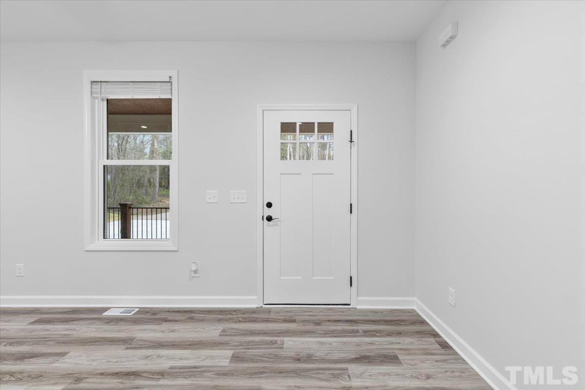 1893 Pilot-Riley Road Zebulon, NC 27597 - Photo 8 of 50 a view of an empty room with wooden floor and a window