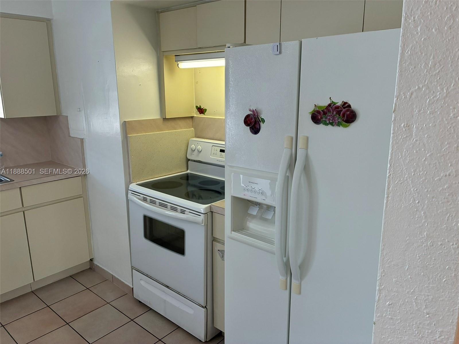 265 West 55th Street Hialeah, FL 33012 - Photo 18 of 58 a kitchen with a refrigerator and white cabinets