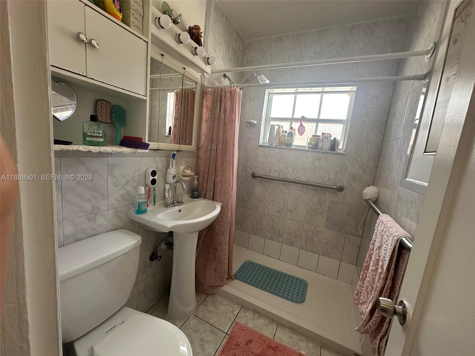 265 West 55th Street Hialeah, FL 33012 - Photo 25 of 58 a bathroom with a sink a toilet a mirror and shower