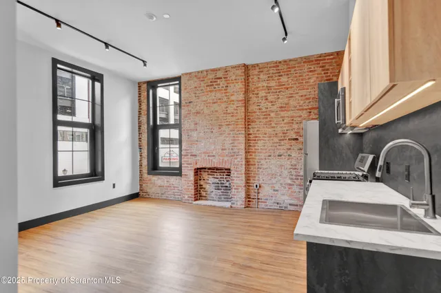 a view of a kitchen with a sink dishwasher and a fireplace