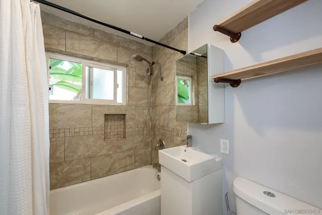 an empty room with wooden floor and a ceiling fan