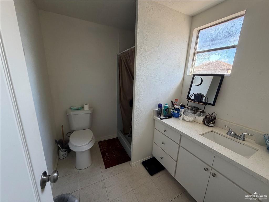 865 Rio Grande Street San Benito, TX 78586 - Photo 3 of 10 a bathroom with a toilet sink and mirror