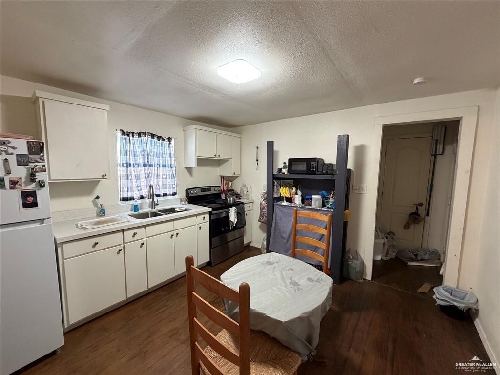 865 Rio Grande Street San Benito, TX 78586 - Photo 7 of 10 a kitchen with sink refrigerator dining table and chairs