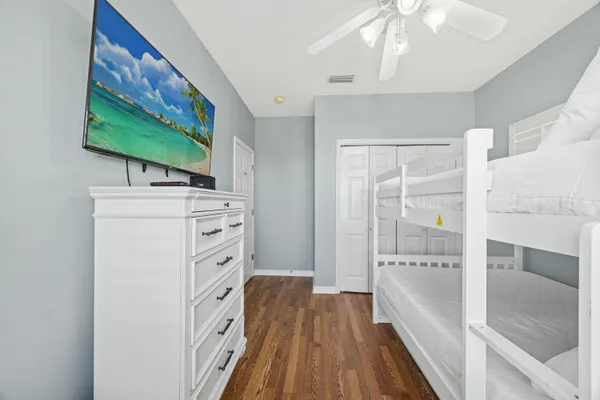 a view of a hallway with wooden floor and a bathroom