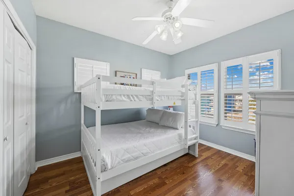 a bedroom with bed and a chandelier fan