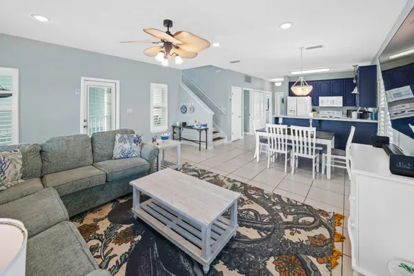 a living room with furniture and a flat screen tv with kitchen view