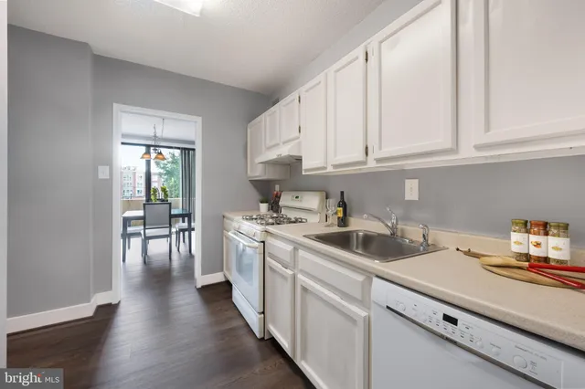 a kitchen with a sink cabinets and wooden floor
