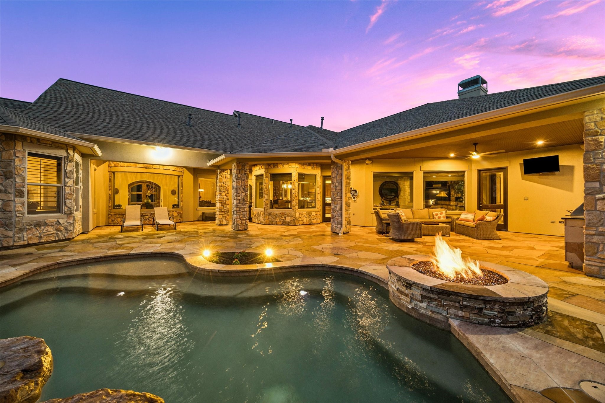 32102 Fulbrook Commons Fulshear, TX 77441 - Photo 2 of 50 The sparkling heated spa pool, fire feature, and expansive covered patio create an unforgettable setting for evening entertaining or peaceful relaxation.