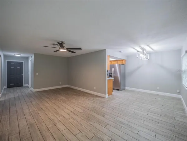 a view of empty room with wooden floor