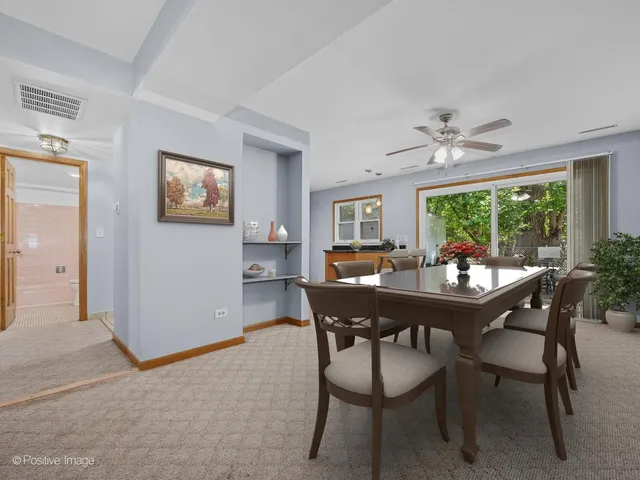 a view of a dining room with furniture a rug and wooden floor