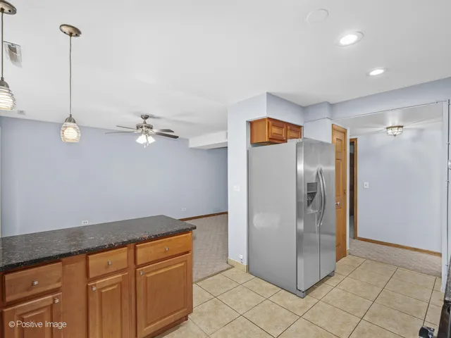 a kitchen with stainless steel appliances granite countertop a refrigerator a sink and a cabinets