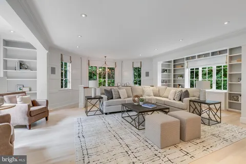 an empty room with wooden floor chandelier fan and windows