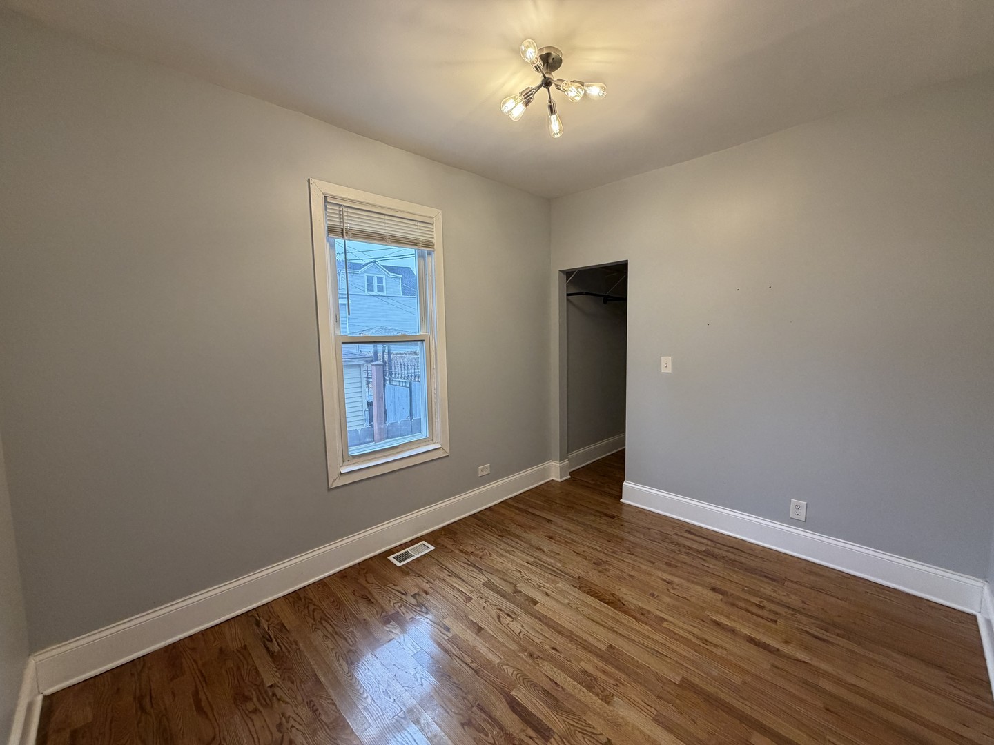 3614 West George Street, Unit 2R Chicago, IL 60618 - Photo 7 of 12 a view of an empty room with wooden floor and a window