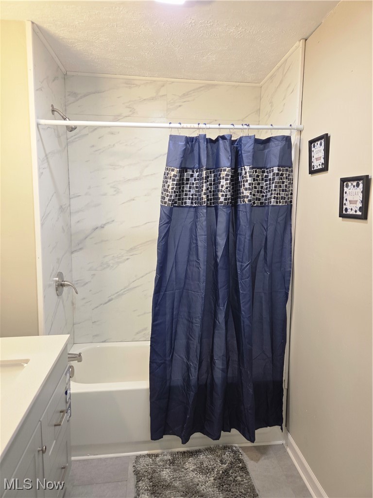 3797 Delmore Road Cleveland, OH 44121 - Photo 21 of 39 Full bathroom featuring a textured ceiling, shower / bath combo, vanity, and light tile patterned floors