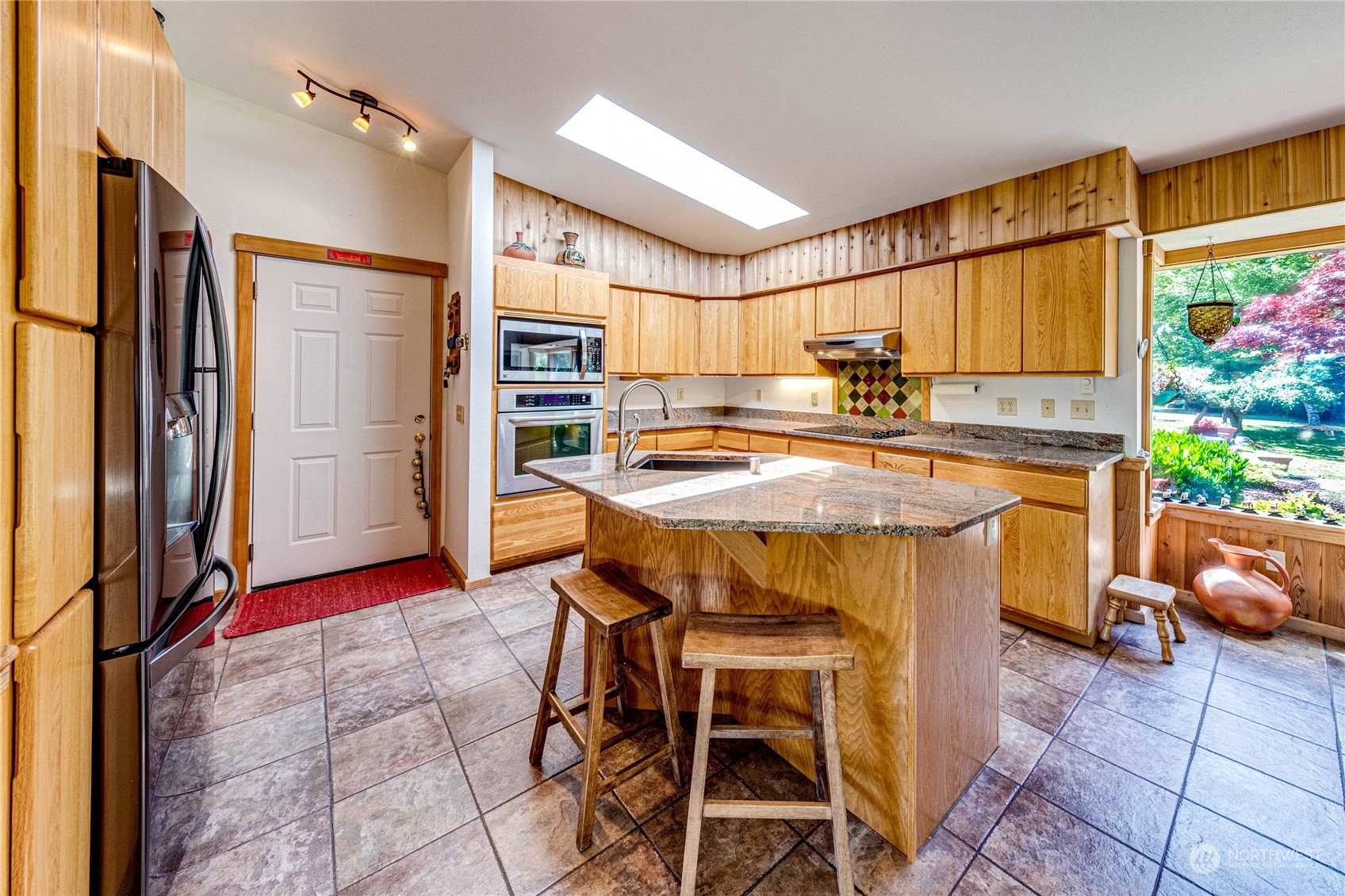 443 Westridge Road Port Angeles, WA 98363 - Photo 13 of 40 a kitchen with a table chairs refrigerator and cabinets