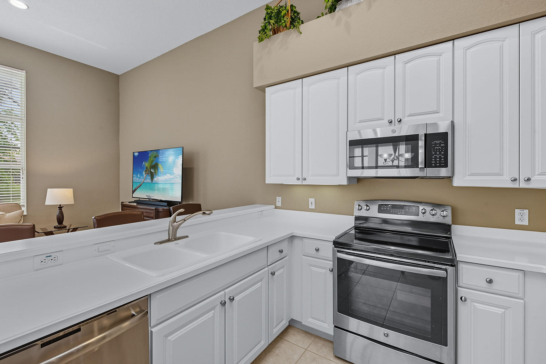 8582 Peppertree Way Naples, FL 34114 - Photo 12 of 50 a kitchen with white cabinets stainless steel appliances and sink