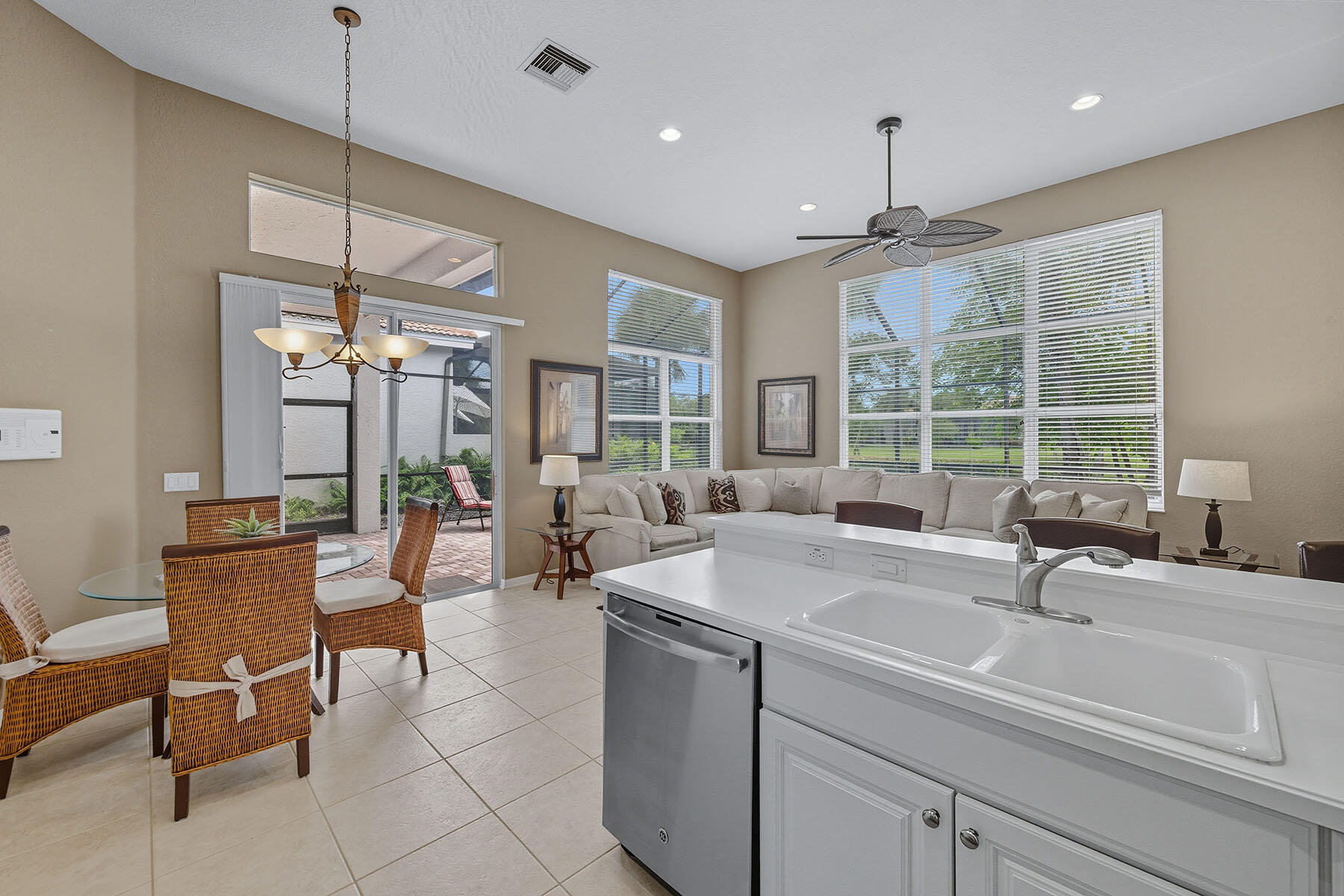 8582 Peppertree Way Naples, FL 34114 - Photo 13 of 50 a kitchen with kitchen island a sink dining table and chairs