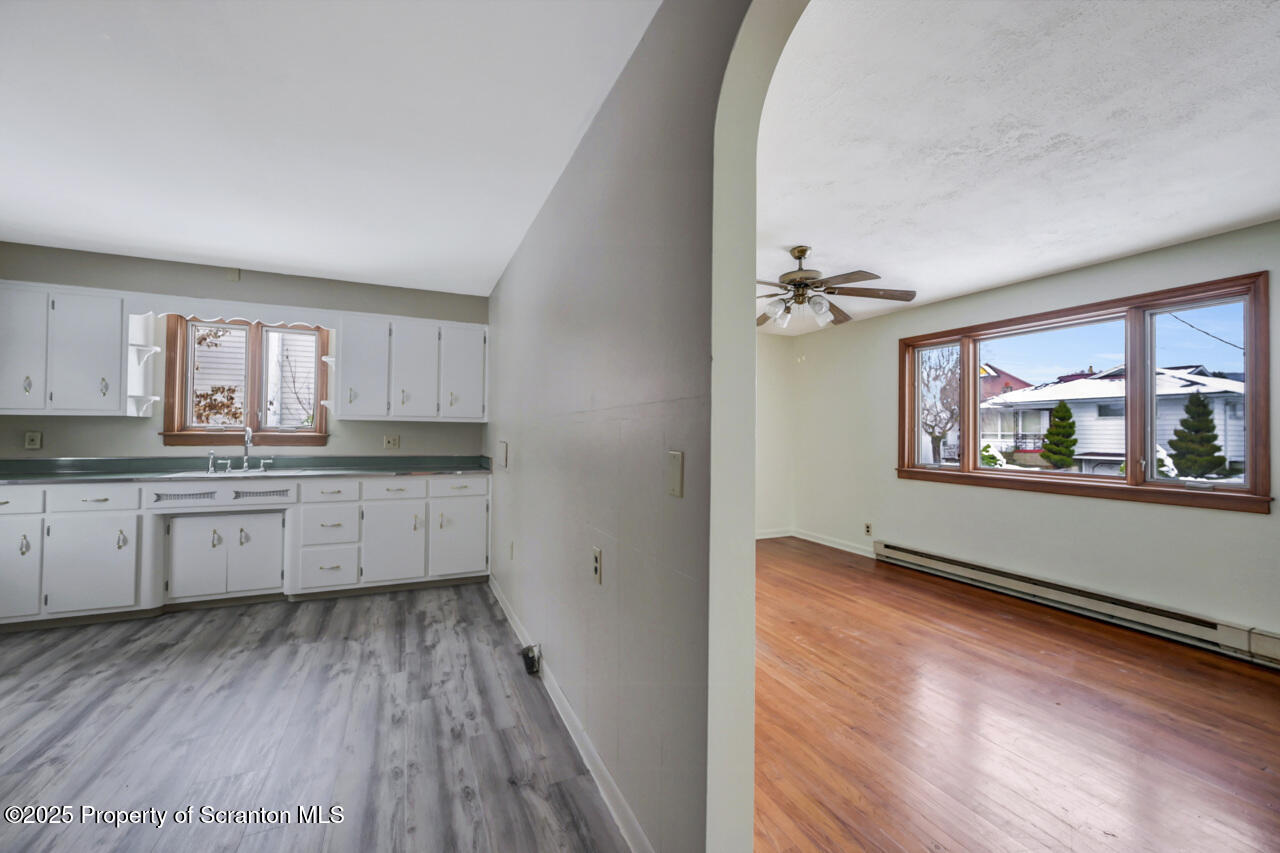 113 Taroli Street Old Forge, PA 18518 - Photo 26 of 41 a kitchen with granite countertop white cabinets and wooden floor