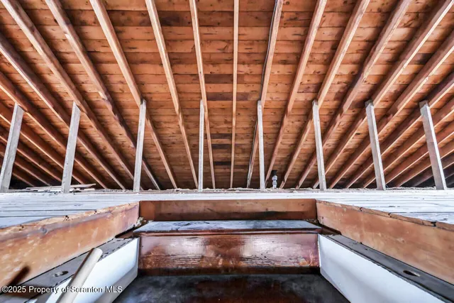 a view of an empty room with wooden ceiling