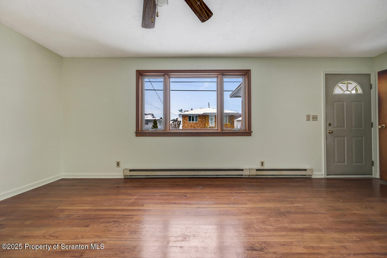 113 Taroli Street Old Forge, PA 18518 - Photo 6 of 41 an empty room with wooden floor and windows