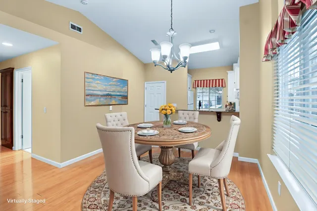 a view of kitchen with a sink wooden cabinets and a window