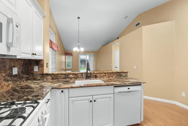 a bathroom with a granite countertop sink toilet and mirror