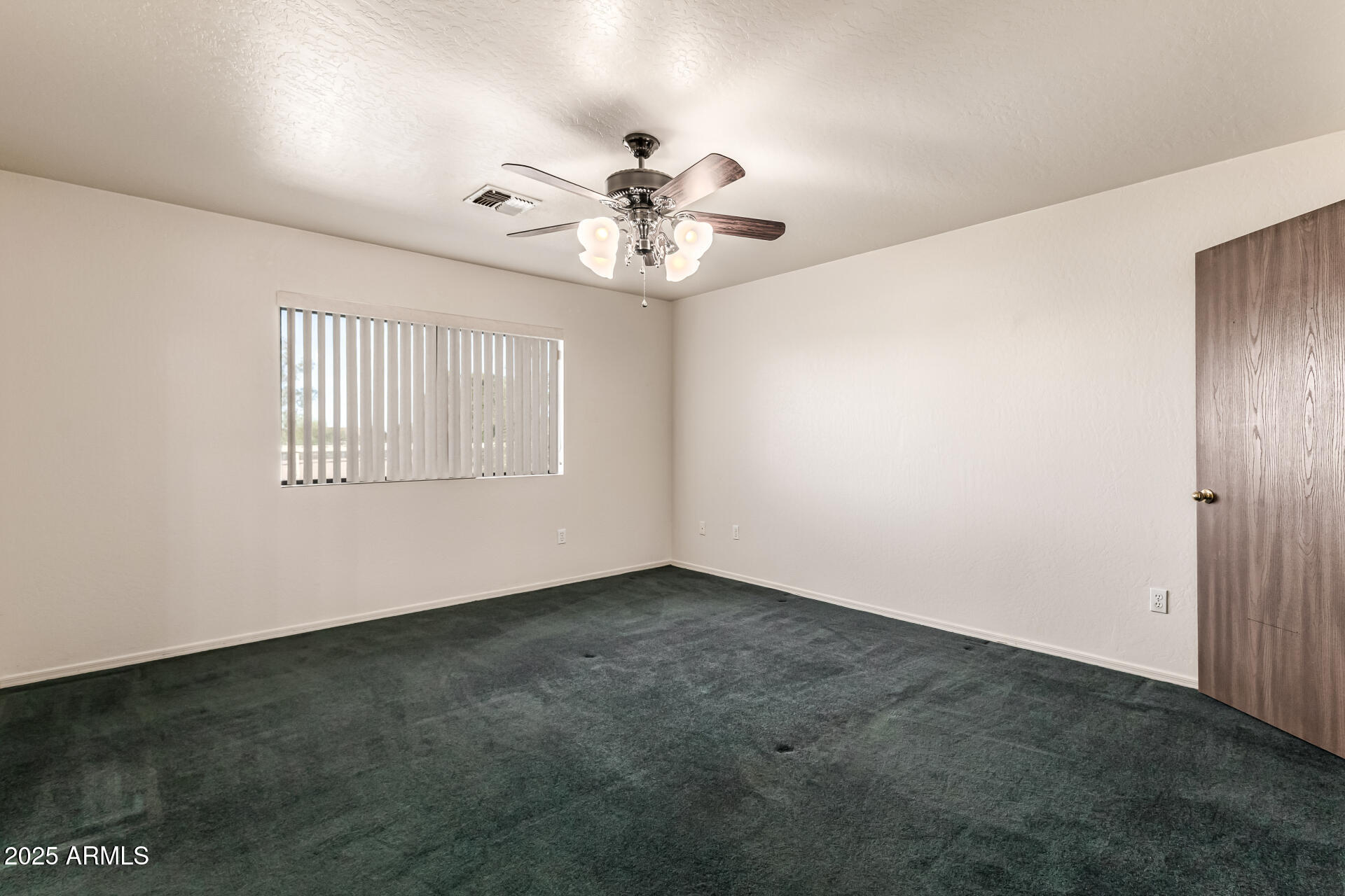 1008 North Meridian Drive Apache Junction, AZ 85120 - Photo 17 of 38 an empty room with windows and fan
