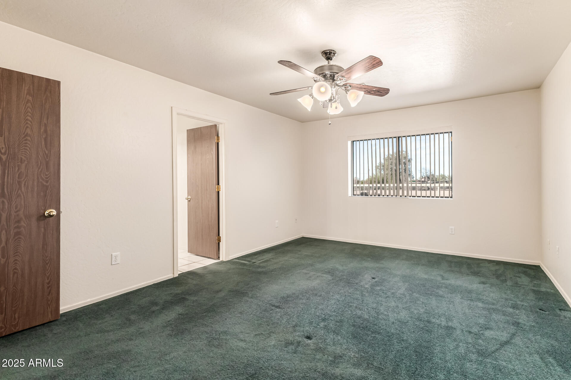 1008 North Meridian Drive Apache Junction, AZ 85120 - Photo 19 of 38 an empty room with windows and fan