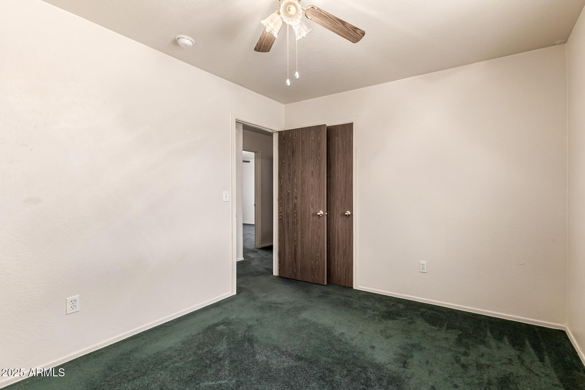 1008 North Meridian Drive Apache Junction, AZ 85120 - Photo 22 of 38 an empty room with a ceiling fan and carpet