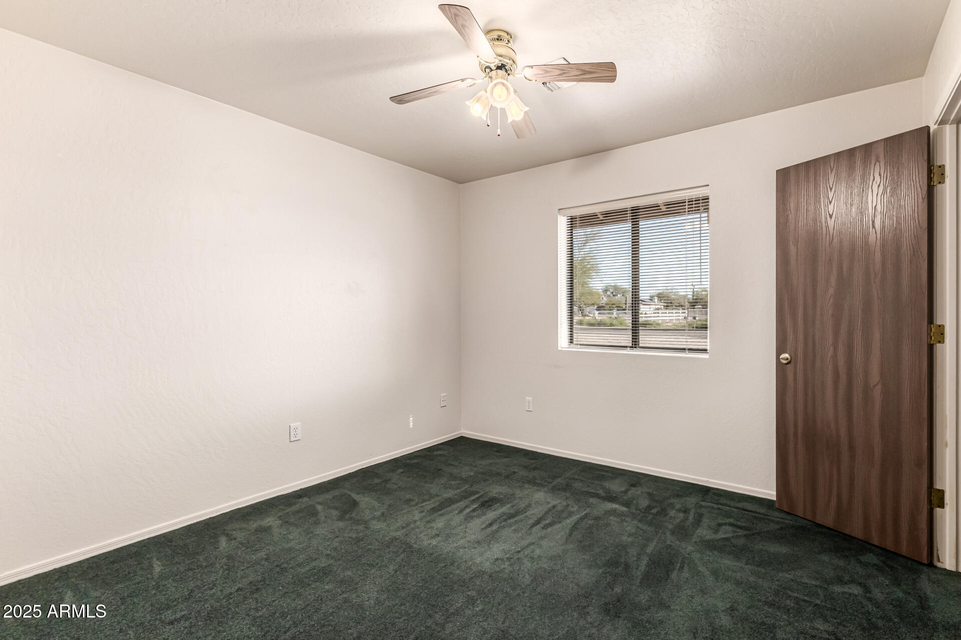 1008 North Meridian Drive Apache Junction, AZ 85120 - Photo 23 of 38 an empty room with windows and fan