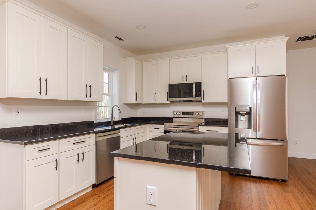 150 State Road East, Unit 12 Westminster, MA 01473 - Photo 3 of 13 a kitchen with cabinets stainless steel appliances a sink and wooden floor