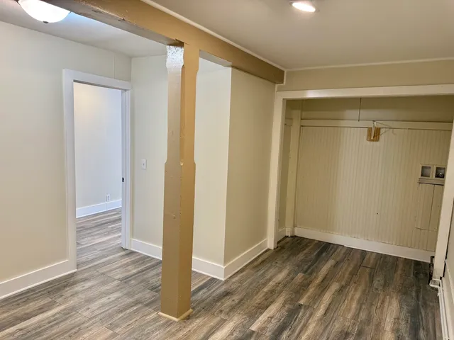 a view of a room with wooden floor and a window