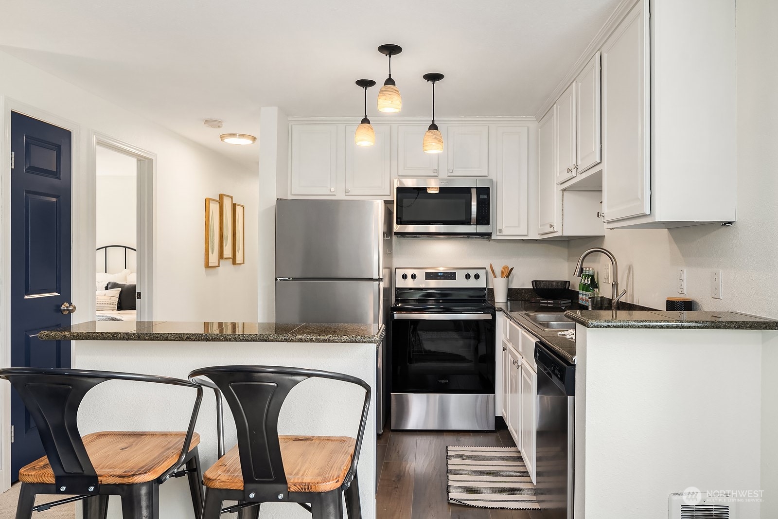 20324 Bothell Everett Highway, Unit F 301 Bothell, WA 98012 - Photo 13 of 28 a kitchen with stainless steel appliances granite countertop a stove a refrigerator a sink dishwasher a dining table and chairs with wooden floor